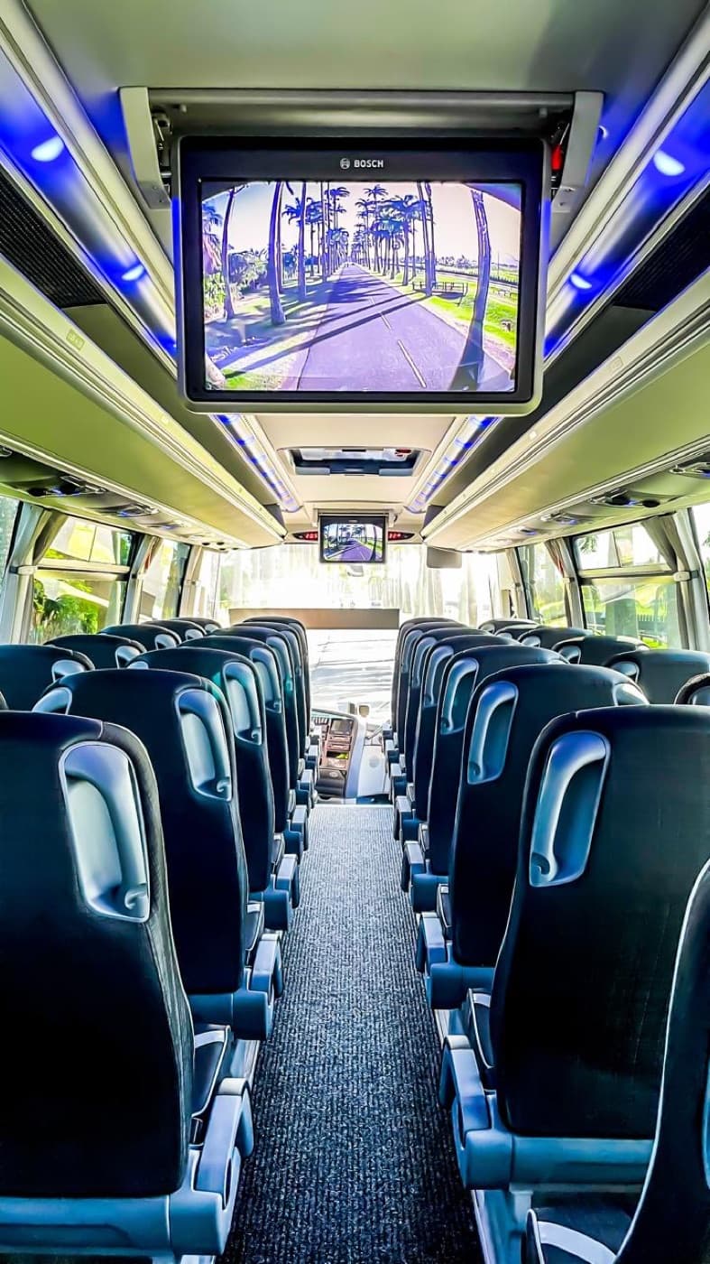 Intérieur de l'autocar grand tourisme : sièges inclinables et écran.
